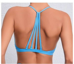 Détail du haut de yoga bleu clair avec design multi-bretelles au dos et tissu élastique