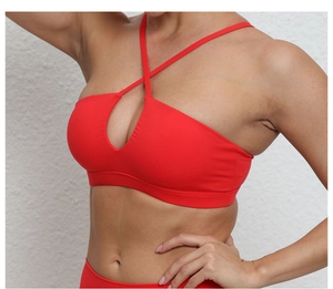 Détail d'un soutien-gorge de sport rouge avec bretelles croisées et découpe poitrine