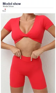 Detail des roten Sport-Crop-Tops und der High-Waist-Fitness-Shorts am Modell