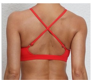 Gros plan du dos d'un soutien-gorge de sport rouge avec bretelles croisées et boucles argent