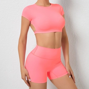 Detail der neonpinken High-Waist-Yoga-Shorts und bauchfreiem Oberteil am Model