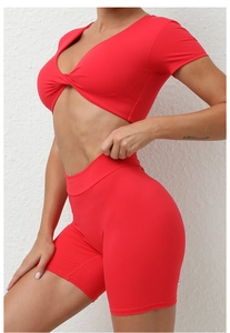 Detail eines roten Yoga-Sets mit Kurzarm-Oberteil in Wickeloptik und High-Waist-Shorts