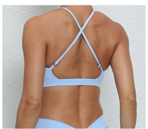 Détail du soutien-gorge de sport bleu clair avec sangles croisées et boucles en métal argenté
