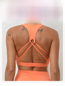 Détail de la brassière de sport orange avec bretelles croisées et tissu élastique respirant