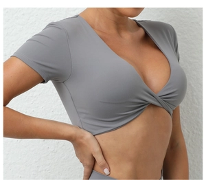 Detalle de top de yoga gris claro con cuello en V, diseño de nudo y tejido elástico pro
