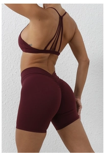 Detail of burgundy yoga set featuring criss-cross back sports bra and scrunch butt shorts