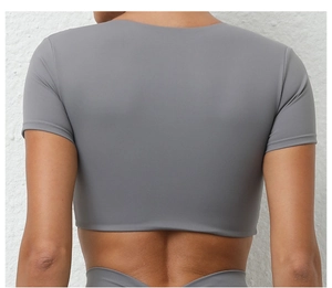Vista trasera de un top deportivo corto gris oscuro con ajuste elástico para yoga