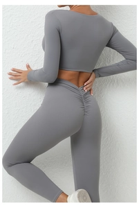 Détail d'un ensemble de yoga gris foncé avec legging effet galbant et haut à manches