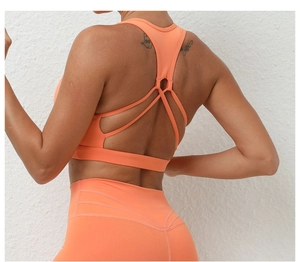 Détail du soutien-gorge de sport orange avec bretelles croisées et tissu élastique