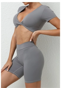 Detail von grauem V-Ausschnitt Sportoberteil und High-Waist Radlerhosen-Set