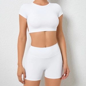 Detail des weißen Yoga-Sets mit kurzem Oberteil und elastischen High-Waist Fitness-Shorts