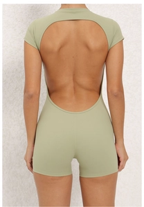 Close-up of open-back cutout detail on a pale green short-sleeve yoga bodysuit