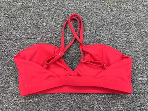 Détail du soutien-gorge de sport rouge avec bretelles croisées et boucles réglables en argent