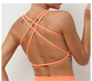 Close-up of orange sports bra with criss-cross back straps and moisture-wicking fabric