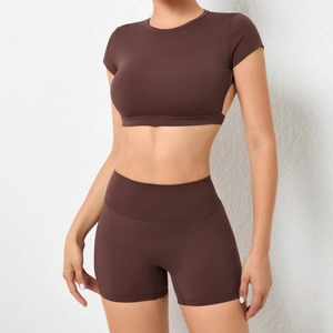 Detail von schokoladenbraunen High-Waist Yoga-Shorts und bauchfreiem Kurzarm-Oberteil