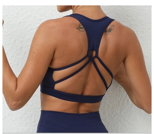 Détail des bretelles croisées sur le soutien-gorge de sport bleu foncé mat fitness