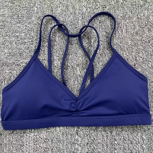 Détail d'un soutien-gorge de sport bleu marine avec fronces et bretelles croisées