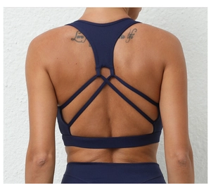 Détail d'un soutien-gorge de sport bleu marine avec bretelles croisées et tissu anti-humidité