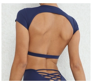 Dettaglio del top da yoga blu scuro con schiena scoperta, ritaglio e lacci in vita