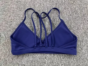 Vue détaillée du dos d'un soutien-gorge de sport bleu marine avec design croisé multi-bretelles