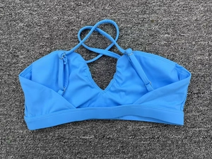Détail de la brassière de sport bleue avec dos croisé et décolleté en V plongeant