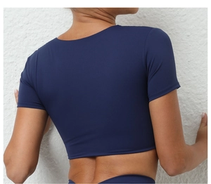 Primer plano de top corto de yoga azul oscuro ajustado con diseño de nudo girado