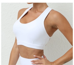 Détail du soutien-gorge de sport blanc avec dos croisé, bande élastique large et tissu brossé