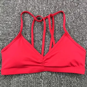 Détail du soutien-gorge de sport rouge avec fines bretelles croisées et col en V