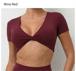 Detalle del cuello en V retorcido en el top corto de yoga burdeos para mujer