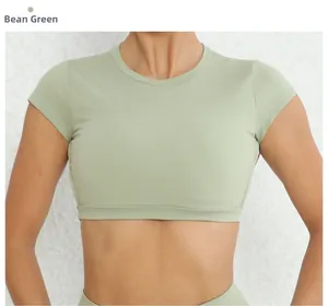 Dettaglio del crop top sportivo verde salvia a maniche corte in tessuto elastico ad asciugatura rapida