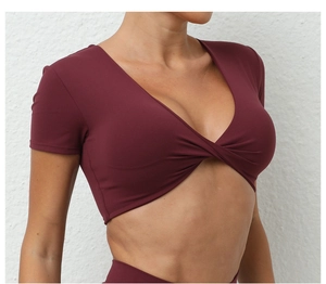 Detalle del diseño cruzado en el top de yoga color vino con cuello en V y tejido elástico