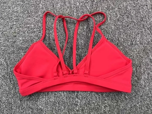 Détail du soutien-gorge de sport rouge avec bretelles croisées dans le dos sur un tapis