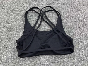 Close-up of black sports bra featuring a complex multi-strap crisscross back design