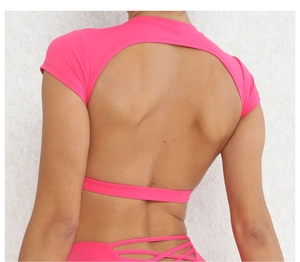 Dettaglio del top da yoga rosa con ampio scollo sulla schiena e tessuto sportivo elastico
