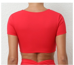 Vista trasera de un top corto rojo para yoga con nudo y tejido deportivo elástico