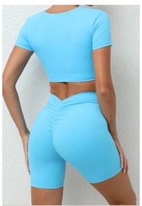 Detail der High-Waist Scrunch Butt Yoga-Shorts und Crop Top aus himmelblauem Sportstoff