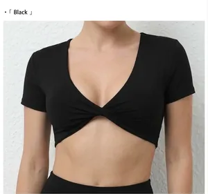 Detalle del cuello en V negro con diseño de nudo frontal en este top corto de yoga ceñido