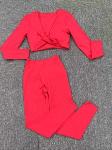 Détail à plat d'un ensemble de yoga rouge avec haut court à manches longues et legging