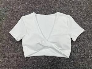 Detalle del crop top blanco de yoga con escote en V profundo y diseño de nudo frontal