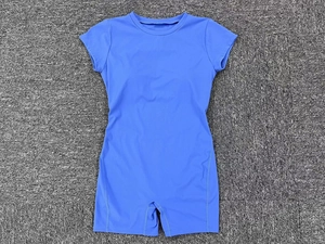 Detailed flat lay of sky blue yoga bodysuit featuring short sleeves and reinforced seams