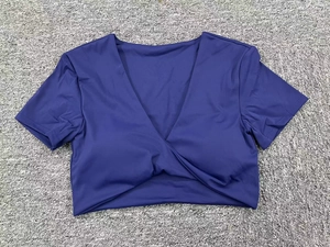 Detalle de top corto de yoga azul marino con cuello en V y diseño de nudo frontal