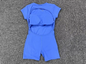 Detail view of the open-back design and built-in bra on sky blue yoga romper