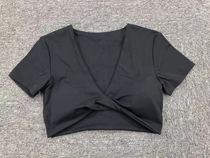 Vista de detalle del top de yoga negro con cuello en V y diseño de nudo cruzado de moda