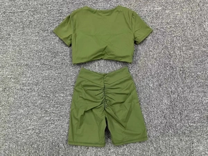 Detailansicht der olivgrünen Yoga-Shorts mit Scrunch-Effekt und bauchfreiem Oberteil im Set