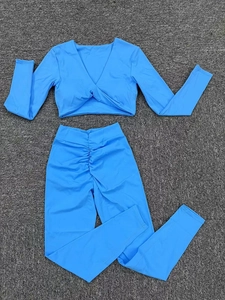 Détail d'ensemble de yoga bleu avec haut court à col en V torsadé et legging taille haute