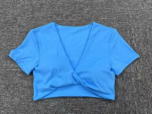 Detalle del crop top de yoga azul eléctrico con cuello en V y diseño de nudo frontal