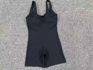 Flat lay of black high-elastic one-piece yoga romper with open back and wide straps