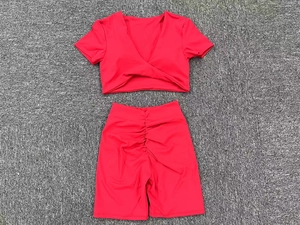 Detailansicht des roten Yoga-Sets mit V-Ausschnitt-Top und High-Waist-Shorts mit Raffung