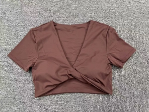 Detalle del dobladillo cruzado y cuello en V de esta camiseta corta de yoga marrón