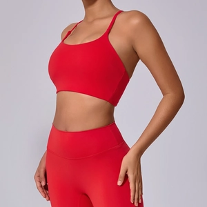 Detailansicht eines roten Yoga-Sets mit Kreuzgurten und nahtlosem Sport-BH mit hoher Taille